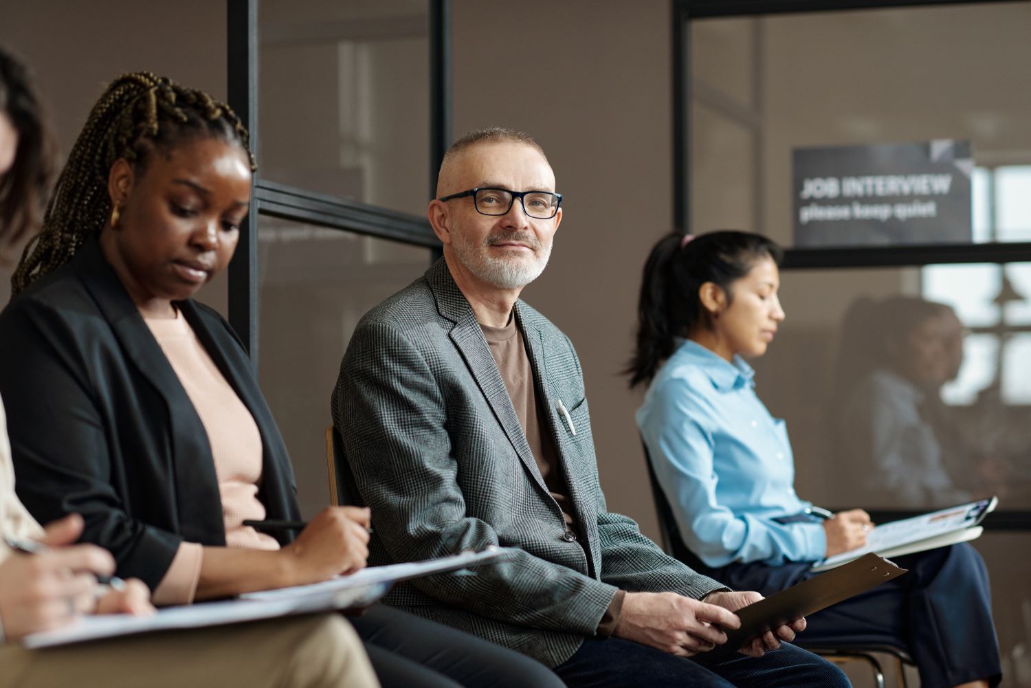 Man sat in a group interview and questioning session.