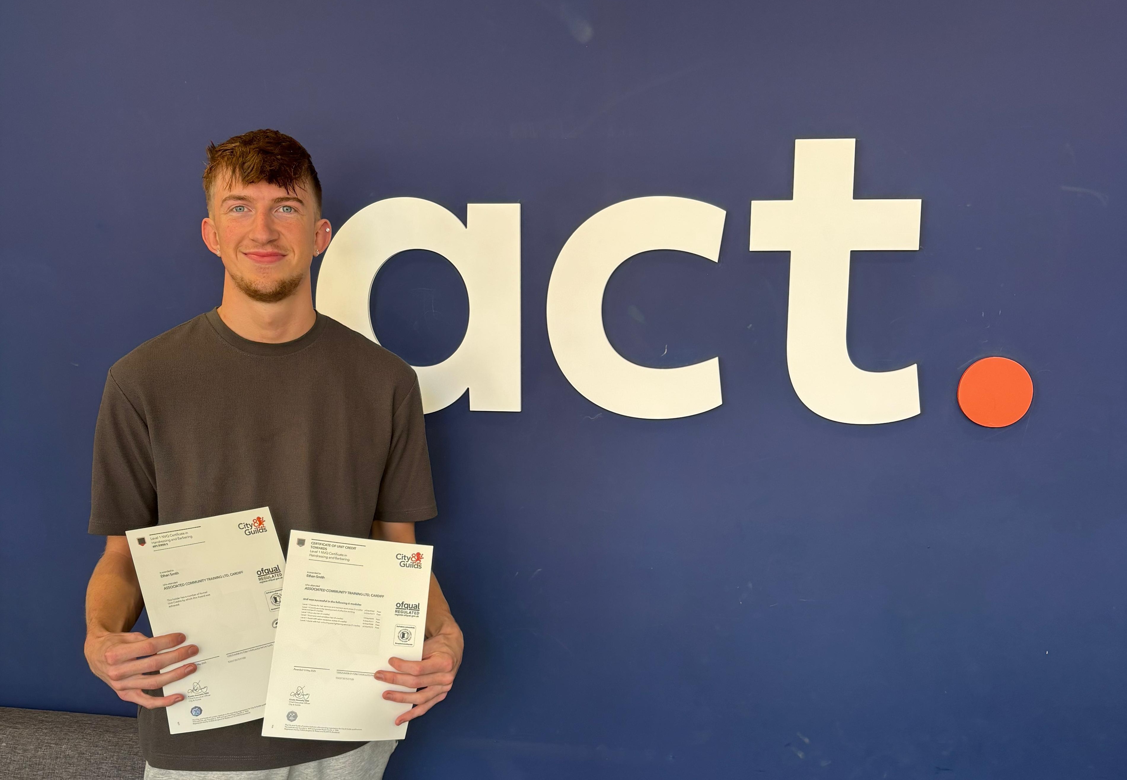 Ethan Smith holding certificates in front of 'act' sign