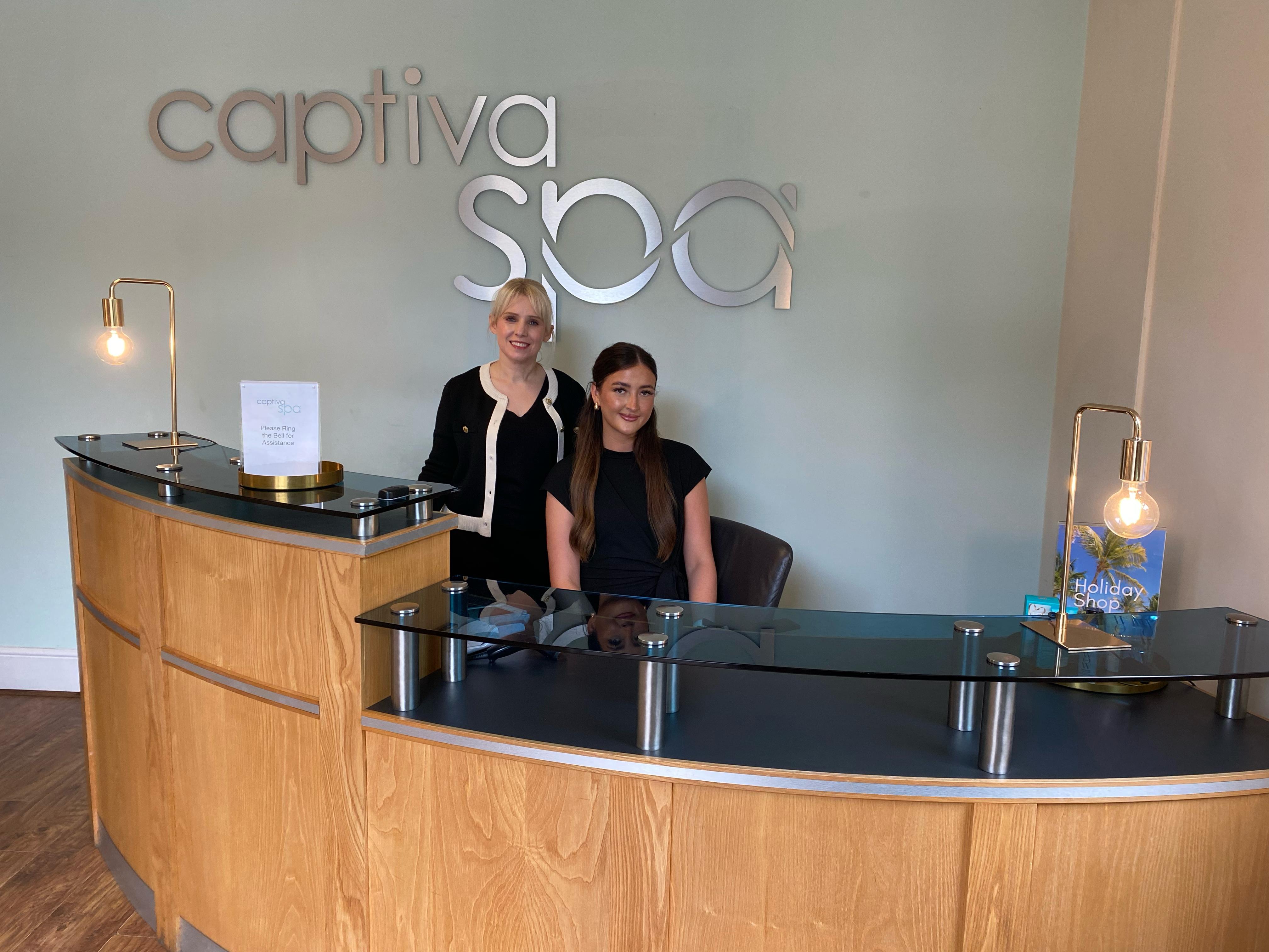 Sarah Bruton and learner Scarlett behind the reception counter at Captiva Spa