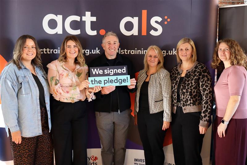 Jonathan 'Jiffy' Davies with employers holding a 'we signed the pledge' sign